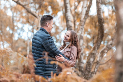 Young couple standing in park during autumn