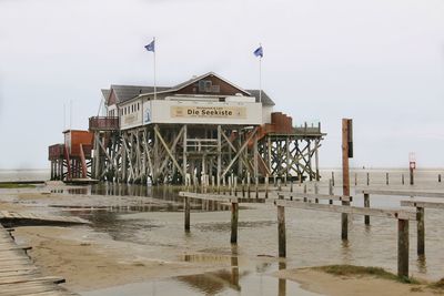 Pier on beach against clear sky