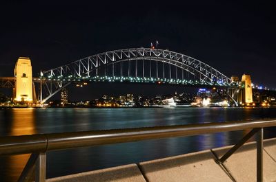 Illuminated sydney harbor bridge against sky at night