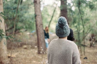 Rear view of woman walking in forest