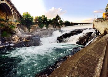 Scenic view of waterfall against sky