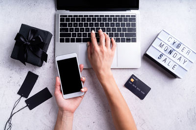 Low section of person using mobile phone on table