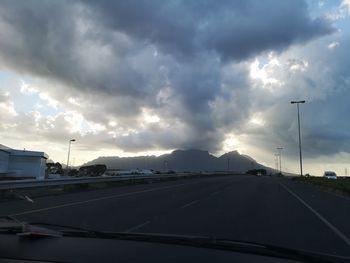 Cars on road against sky seen through car windshield