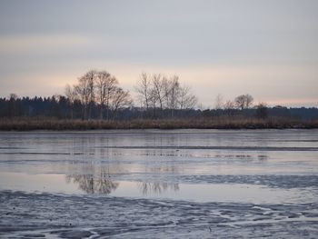 Scenic view of frozen lake against sky during sunset