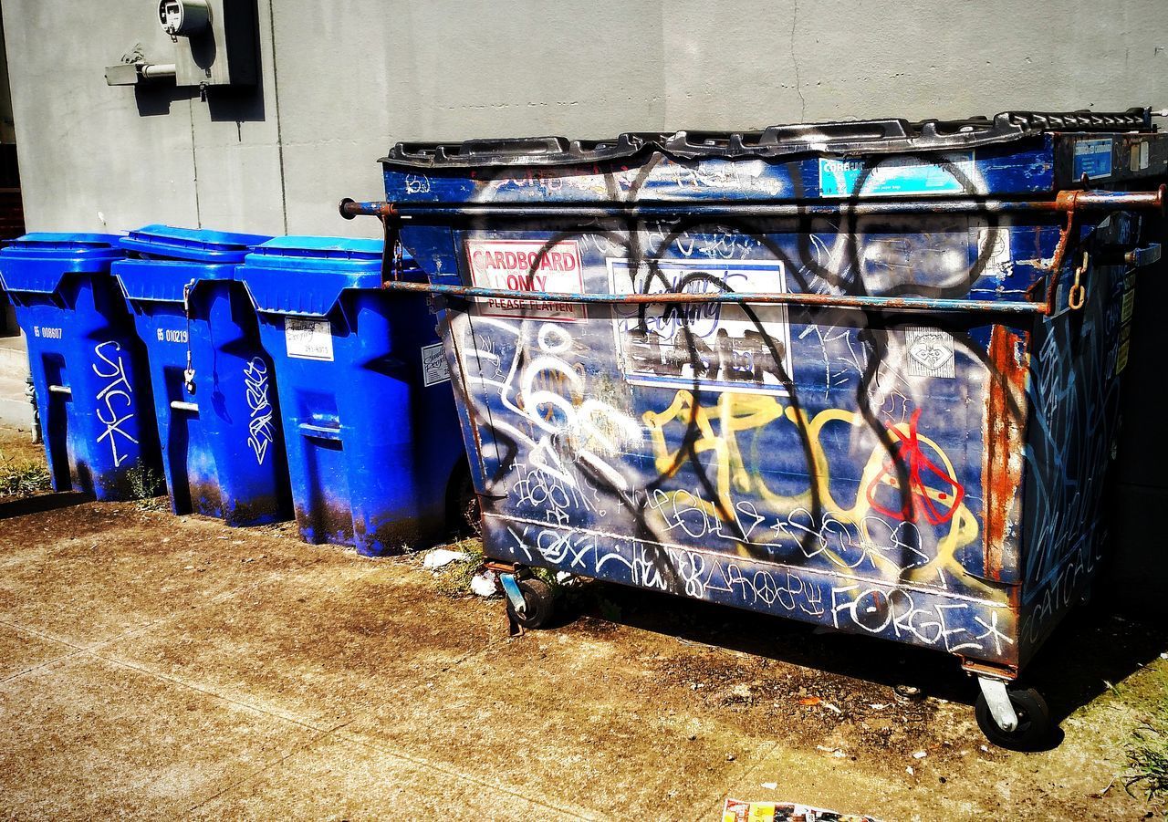 MULTI COLORED GARBAGE BIN AGAINST BLUE SKY