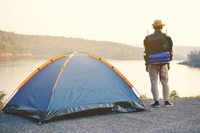 Rear view of man standing at tent against sky