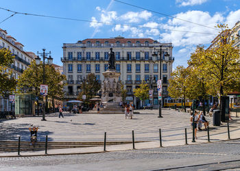 People on street against buildings in city