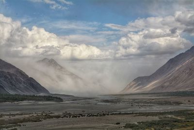 Scenic view of sea and mountains against sky