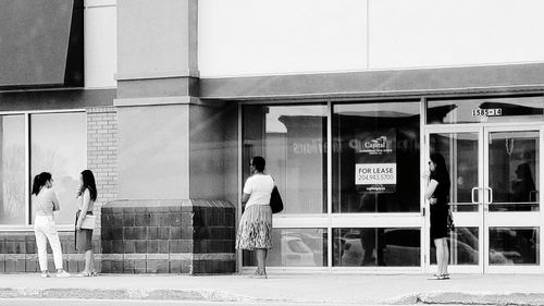 Rear view of people walking on glass window