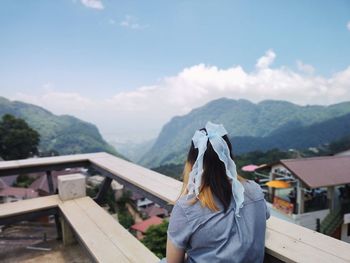 Rear view of woman standing against mountain