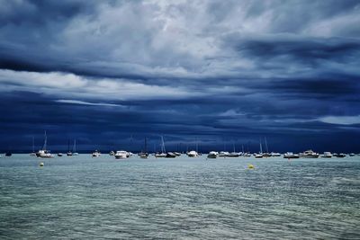 Sailboats in sea against sky