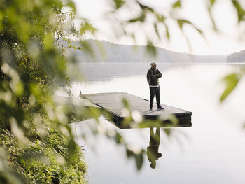 Full length of man standing by lake