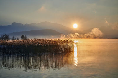 Scenic view of lake against sky during sunrise