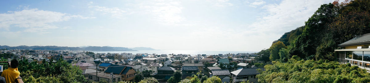 High angle view of town by sea against sky