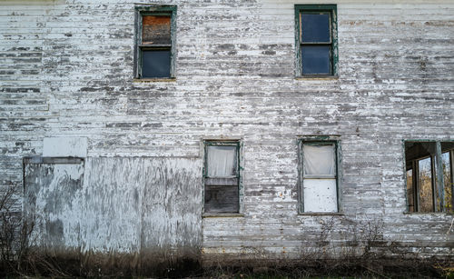 Windows of abandoned and weathered wood house