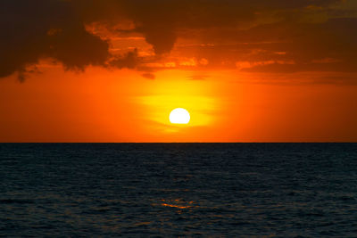 Scenic view of sea against dramatic sky during sunset