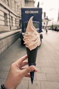 Midsection of woman holding ice cream in city