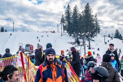 People on snow covered tree against sky