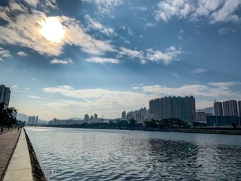 River amidst buildings in city against sky