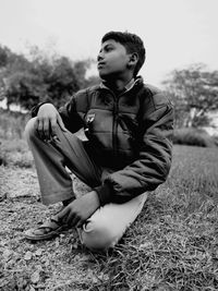 Young man sitting on field