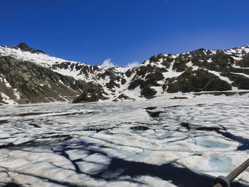 Scenic view of snowcapped mountains against clear blue sky