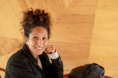 Happy latin woman smiling while sitting indoors.