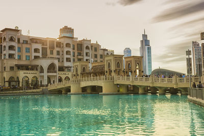 Bridge over river against buildings in city