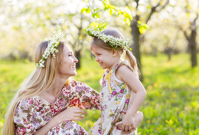 Mother and daughter wearing flowers outdoors