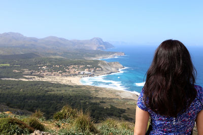 Rear view of woman standing on beach