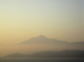 Scenic view of silhouette mountains against clear sky during sunset