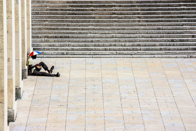 Man sitting on footpath