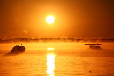 Scenic view of sea against orange sky