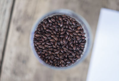 Directly above shot of roasted coffee beans in container on table