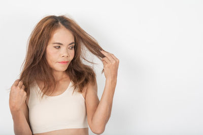 Portrait of beautiful young woman against white background