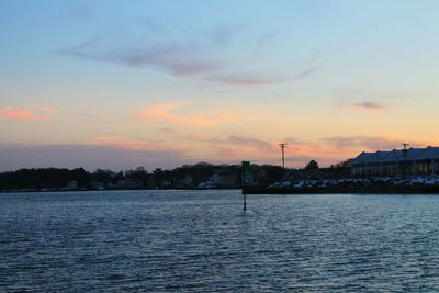 Scenic view of river against sky at sunset