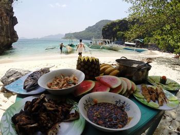 Food on table by sea against sky