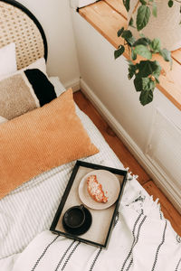 Breakfast in bed a cup of coffee and a delicious croissant on a plate on a tray in a cozy house