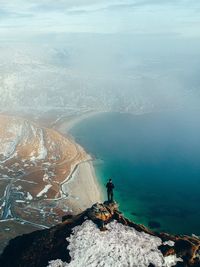 High angle view of man standing on cliff against sea