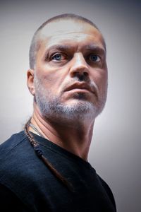 Close-up portrait of man wearing eyeglasses against gray background