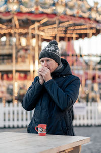 Portrait of young man using mobile phone in city