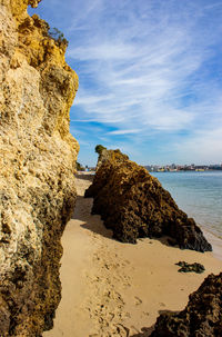 Rock formation on beach against sky