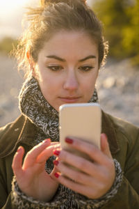 Close-up of woman using mobile phone at beach