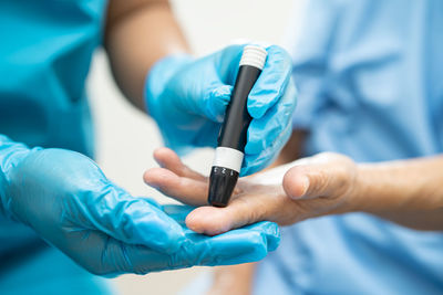 Midsection of doctor holding test tube