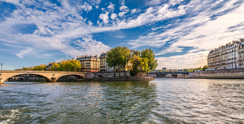 Bridge over river in city against sky