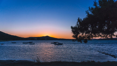 Scenic view of sea against clear sky at sunset