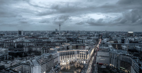 Aerial view of buildings against cloudy sky