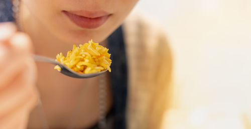 The asian girl hand holding spoon and eating the egyptian curry fried rice food at the restaurant.