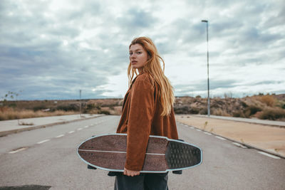 Woman standing on road against sky