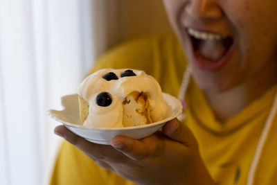 Selective focus cheesecake topped with white cream blueberry paste on top in the hands