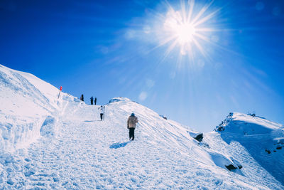 People skiing on snowcapped mountain against sky